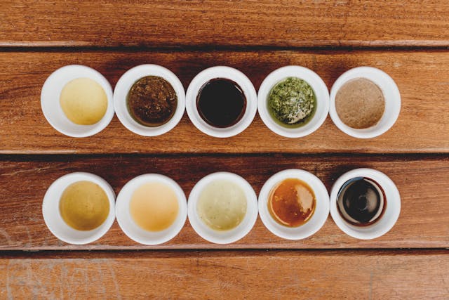 10 colorful homemade dipping sauces for chicken tenders in white bowls.