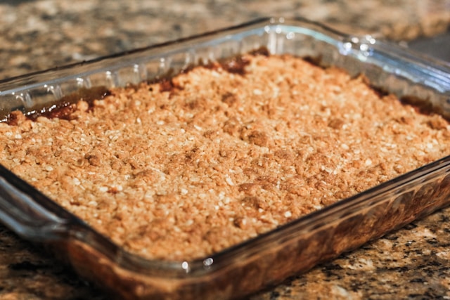 	Warm slow cooker apple crisp in bowl with cinnamon oat topping - easy 5-ingredient dessert
