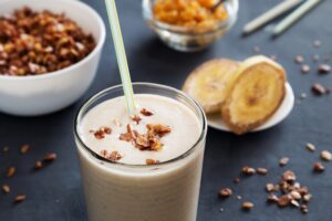Creamy banana date smoothie in glass with cinnamon dust and straw - healthy no-sugar breakfast drink
