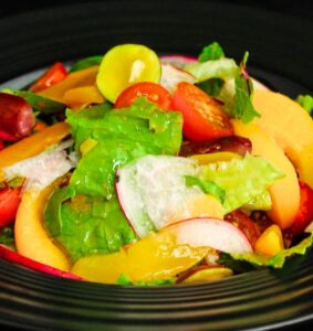 Grilled peach salad with burrata, prosciutto, and arugula on white platter - quick healthy summer recipe