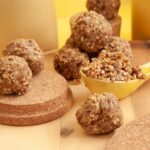 Assorted no-bake energy bites and healthy lunchbox desserts on a wooden board