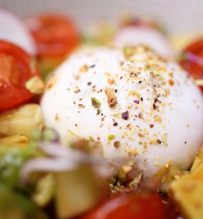 Grilled peach salad with burrata, prosciutto, and arugula on white platter - quick healthy summer recipe