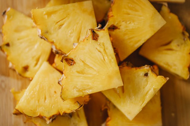 Fresh crushed pineapple and chipotle peppers in adobo sauce being stirred in a saucepan