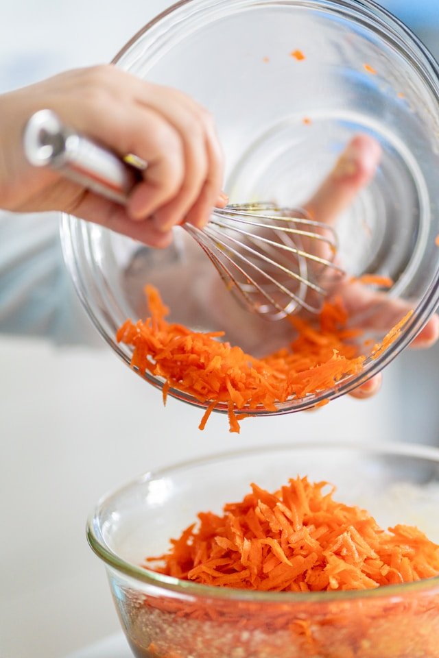 Shredded carrots adding natural sweetness to homemade broccoli cheddar soup
